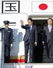 Japanese Prime Minister Fumio Kishida (C) waves at Tokyo's Haneda airport as he boards a government plane to head to the United Arab Emirates to attend a U.N. conference on climate change. (Kyodo)