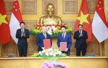Prime Minister Pham Minh Chinh (R) and Singaporean Prime Minister Lawrence Wong (L) witness the exchange of the cooperation agreement between the Vietnam-Singapore Friendship Association and the Singapore International Foundation. (Photo: VNA)