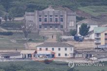 This file photo, taken May 30, 2023, from South Korea's border city of Paju, 37 kilometers northwest of Seoul, shows buses (circled red), presumed to be used at the Kaesong Industrial Complex, parked at a nearby North Korean border town. (Yonhap)