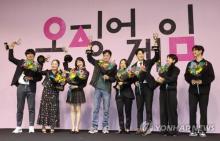 The director and cast of "Squid Game" wave during a news conference at a Seoul hotel, in this file photo taken Sept. 16, 2022, to mark the dystopian drama's winning of six Emmy awards. The global smash hit Korean-language Netflix show won best director, best actor, guest acting, stunts, production design and visual effects at the 74th Emmy Awards in Los Angeles on Sept. 12. (Yonhap)