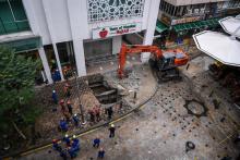 Rescuers widen operation for a woman who is still missing after being swallowed by a sinkhole along Masjid India Road in Kuala Lumpur on Friday.