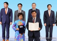 Yonhap News Agency President and CEO Hwang Dae-il (R, front row) and Vietnam News Agency General Director Vu Viet Trang (L, front row) hold up a bilateral memorandum of understanding during the South Korea-Vietnam Business Forum MOU exchange ceremony at the Lotte Hotel in downtown Seoul on Aug. 12, 2025, while Vietnam's top leader To Lam (2nd from R, second row) and South Korean Prime Minister Kim Min-seok (2nd from L, second row) watch. (Yonhap)
