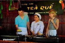 Foreign tourists experience making "banh xeo" in Tra Que vegetable village, Hoi An city, Quang Nam province (Photo: VNA)