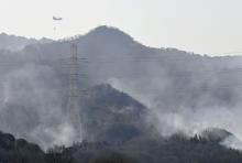 A helicopter conducts firefighting operations in Okayama, western Japan, on March 26, 2025. (Kyodo)