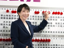 Prime Minister Sanae Takaichi, head of the Liberal Democratic Party, attaches a rosette to the name of an LDP candidate assured of victory in the House of Representatives election on Feb. 8, 2026, at the party's headquarters in Tokyo. (Kyodo)