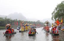 The dragon boat procession takes place on Sao Khe River at Trang An Landscape Complex during the festival. (Photo: VNA)