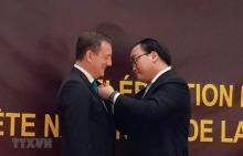 Secretary of the Hanoi municipal Party Committee Hoang Trung Hai (R) presents a Friendship Order to French Ambassador Bertrand Lortholary (Photo: VNA) 