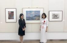 Vu Nguyen Huong Nhi (R) and her painting "Night sea" at the festival (Source: VNA)